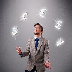 young man standing and juggling with currency icons
