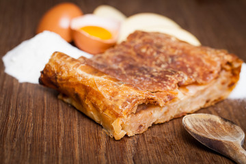 Apfelstrudel mit Zutaten auf Holzbrett