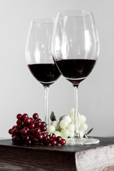Copas de vino con uvas. Botellas de vino de fondo.