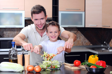 Little boy and his father cooking in the kitchen