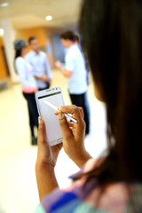 Backview of smartphone screen held by student