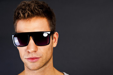 Obraz premium Handsome man in gray tank top with smile and sunglasses
