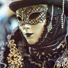 Person in Venetian costume attends Carnival of Venice.