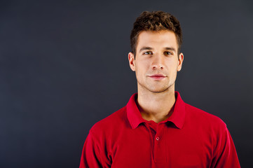 Obraz premium Man on black background in red shirt with smile