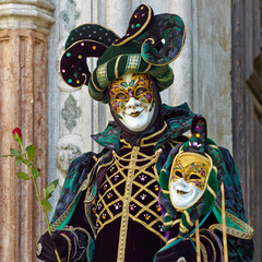 Person in Venetian costume attends Carnival of Venice.