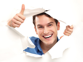 Man with thumbs up peeping through paper hole