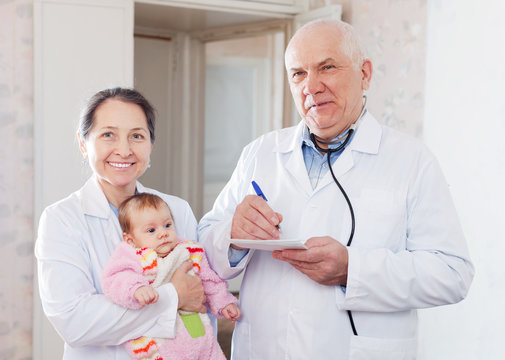  mature pediatrician doctors with  baby