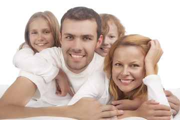 portrait of four caucasian family members lying down in white cl