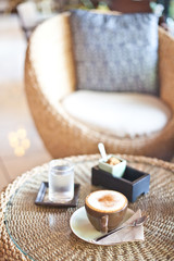 hot cappucino on wood table with pure water