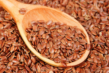 close up of flax seeds and wooden spoon food background