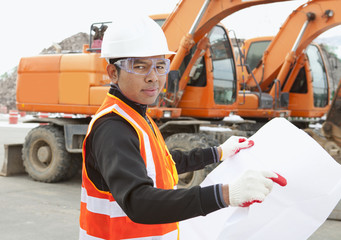 Fototapeta premium road construction worker in front of excavator