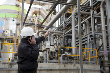 oil gas engineer pointing against pipeline