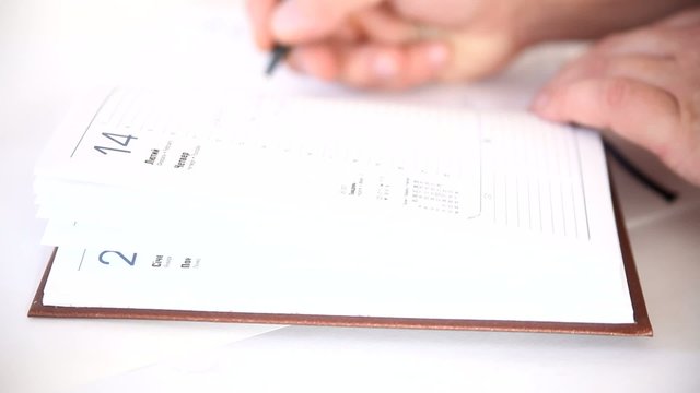 Man writing information in agenda book