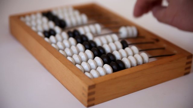 Male hand using the abacus to calculate basic algebra