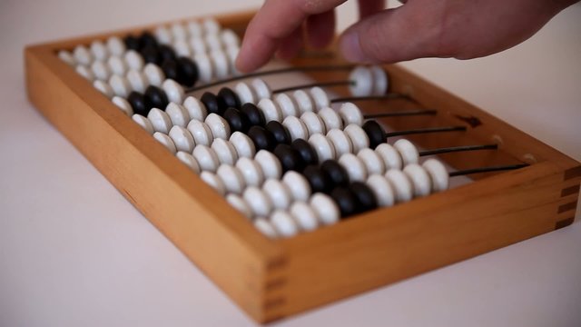 Male hand using the abacus to calculate basic algebra