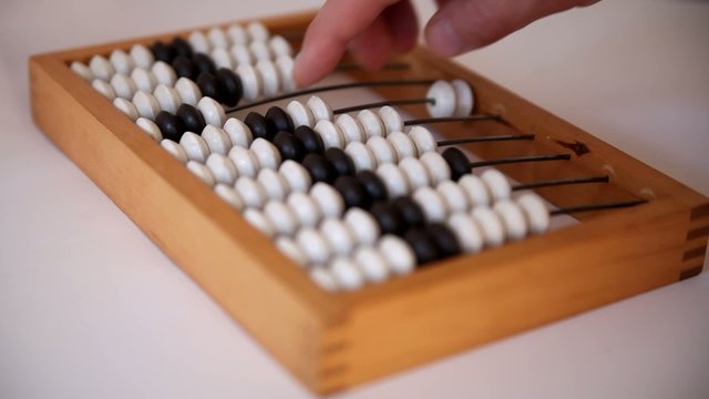 Male hand using the abacus to calculate basic algebra