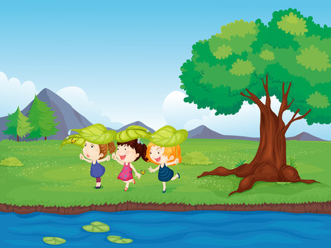 Three girls playing beside the pond