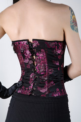 Rear view of a woman in black corset with floral embroidery