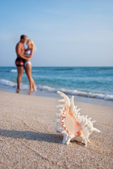 Fototapeta na wymiar loving couple hug one another on the sea sand beach against big