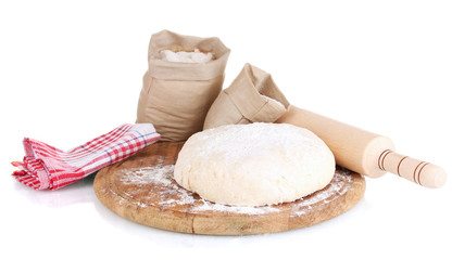 Dough and bags with flour on wooden board isolated on white