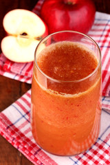 Glass of fresh apple juice on wooden table