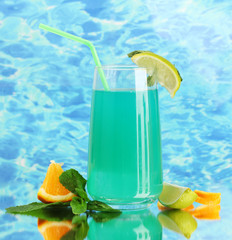 Glass of blue cocktail on blue background