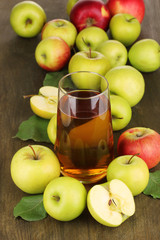 Useful apple juice with apples around on wooden table