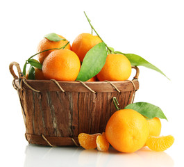 Ripe sweet tangerine with leaves in basket, isolated on white