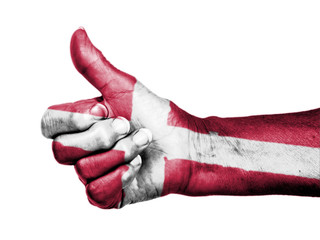 Old woman with arthritis giving the thumbs up sign, wrapped in f