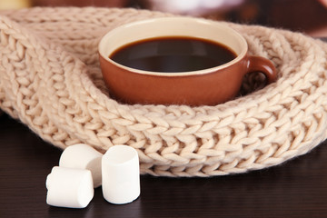 cup of coffee with scarf on table in room