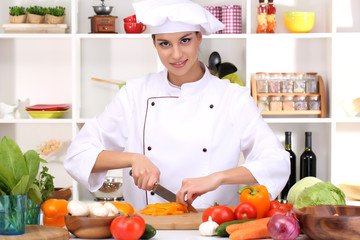 Young woman chef cooking in kitchen