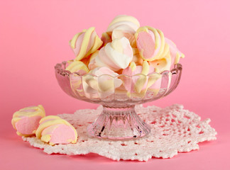 Gentle marshmallow in glass vase on pink background