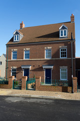 A pair of new semi-detached three storey homes with dormer windo