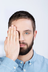 mann hält ein auge zu