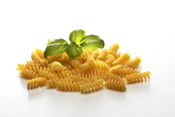 close up with macaroni and basil on white background
