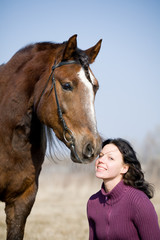 Young girl and bay horse at spring