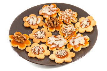 Plate with homemade butter cookies with caramel, walnut, almond