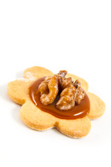 Single homemade cookie with little caramel and walnut on white b
