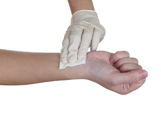 Hand pressing gauze on arm after administering an injection.