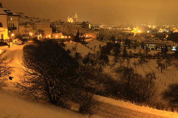 Night snowy Prague City with gothic Castle, Czech Republic