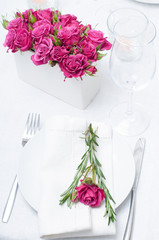 Festive dining table setting with pink roses