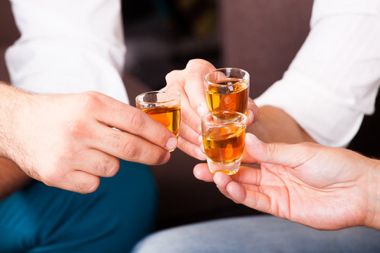 M&auml;nner beim Ansto&szlig;en mit Rum