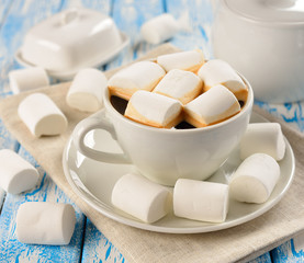 Fototapeta na wymiar Coffee with marshmallows on a blue table