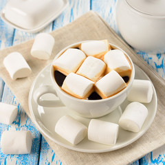 Coffee with marshmallows on a blue table