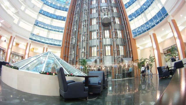 In hall of business-center go lifts upwards and downwards and go