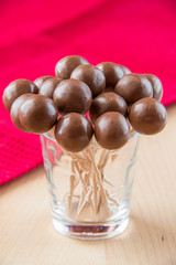 Chocolate balls on stick in glass