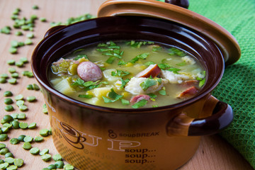 Pea soup with smoked sausages in a pot