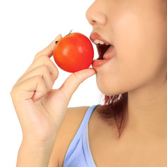 Isolated young asian woman with a tomato