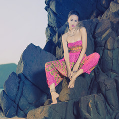 Glamorous beauty on rocky shore