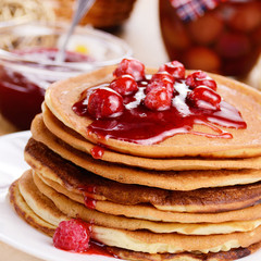Delicious pancakes with raspberries on the wooden kitchen  table